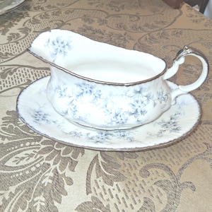 Peut inclure: Ensemble de trois mugs en céramique crème, avec un glaçage moucheté. Chaque mug présente un motif floral peint à la main en bleu, vert et jaune. Les mugs ont une forme arrondie et une anse.