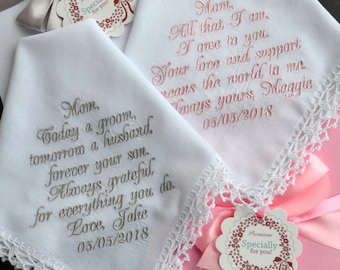 May include: White handkerchiefs with embroidered messages and lace trim. One reads "Mom, Today a groom, tomorrow a husband, forever your son. Always grateful for everything you do. Love, Jake 05/05/2018." Another says "Mom, All that I am, I owe to you. Your love and support means the world to me. Always yours, Maggie 05/05/2018."