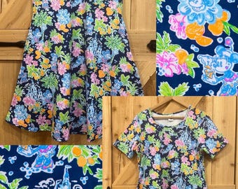Vestido Disney Minnie Mouse con estampado tropical veraniego en azul marino y rosa. Disponible en manga corta y sin mangas, con bolsillos. Listo para enviar. Tallas regulares y plus.