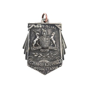 May include: A silver medal with the text "Provincial BC Junior & Juvenile Football Assn" and the coat of arms of British Columbia.