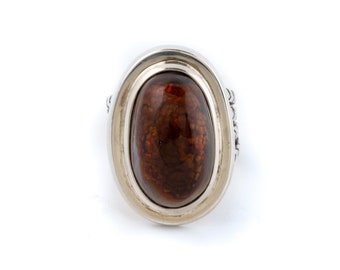 Op de afbeelding: Een zilveren ring met een ovale bruine agaat edelsteen gezet in een bezel setting. De ring heeft een getextureerde band.