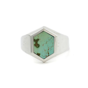 May include: A silver ring with a hexagonal turquoise stone.