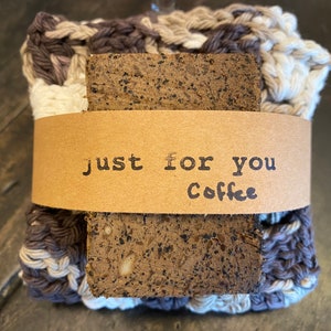 May include: A brown and white crocheted soap saver with a bar of coffee soap inside. The soap saver has a brown paper tag that says "Just for you Coffee".