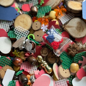 May include: A selection of craft supplies including wooden circles, hearts, and stars, plastic mesh squares, beads, and a small bag of red, white, and blue felt flowers.