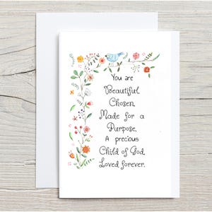 May include: A white greeting card featuring a watercolor illustration of a blue bird and colorful flowers along the left side. The text reads: You are Beautiful, Chosen, Made for a Purpose, A precious Child of God, Loved forever. A blank envelope is behind.