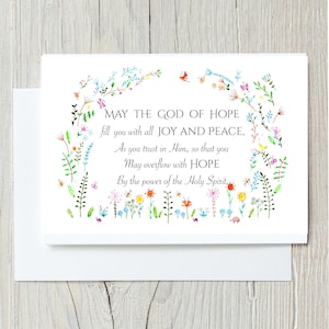 May include: A white greeting card featuring a colorful watercolor floral border with small insects and the text: MAY THE GOD OF HOPE fill you with all JOY AND PEACE, As you trust in Him, so that you May overflow with HOPE By the power of the Holy Spirit.