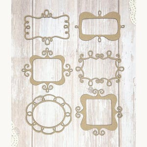 May include: Six decorative wooden frames in various shapes and sizes. The frames are unfinished, with ornate scrollwork and cut-out designs. The frames are arranged on a light wood-grain background.