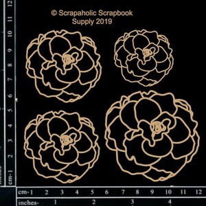 May include: Four die-cut paper flower shapes in a light brown color. The flowers are in different sizes and are arranged in a row. The flowers are on a black background with a ruler in inches and centimeters.