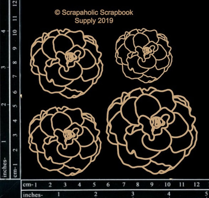 May include: Four die-cut paper flower shapes in a light brown color. The flowers are in different sizes and are arranged in a row. The flowers are on a black background with a ruler in inches and centimeters.