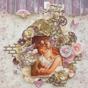 May include: A scrapbook page with a vintage aesthetic featuring a young girl holding a white rabbit. The page is decorated with paper flowers, lace, and a clock. The text "smile today" is written in cursive on the page.