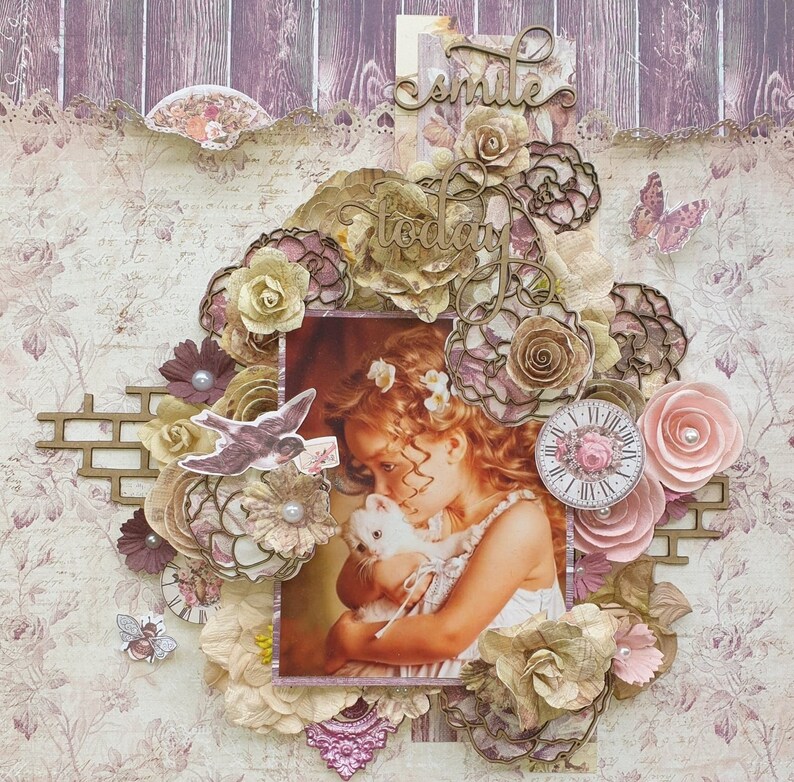 May include: A scrapbook page with a vintage aesthetic featuring a young girl holding a white rabbit. The page is decorated with paper flowers, lace, and a clock. The text "smile today" is written in cursive on the page.