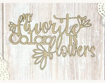 May include: A wooden sign with the phrase "MY favorite COLOR IS flowers" in a cursive font. The sign is light brown and features floral accents. The background is a light wood grain.