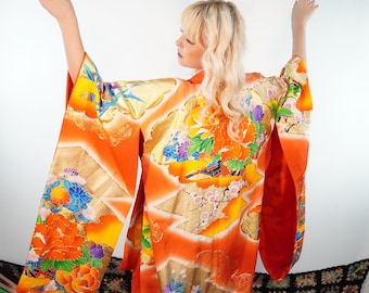 Può includere: Un kimono giapponese tradizionale con un vivace motivo arancione, oro e floreale. Il kimono ha maniche lunghe e una gonna fluida.