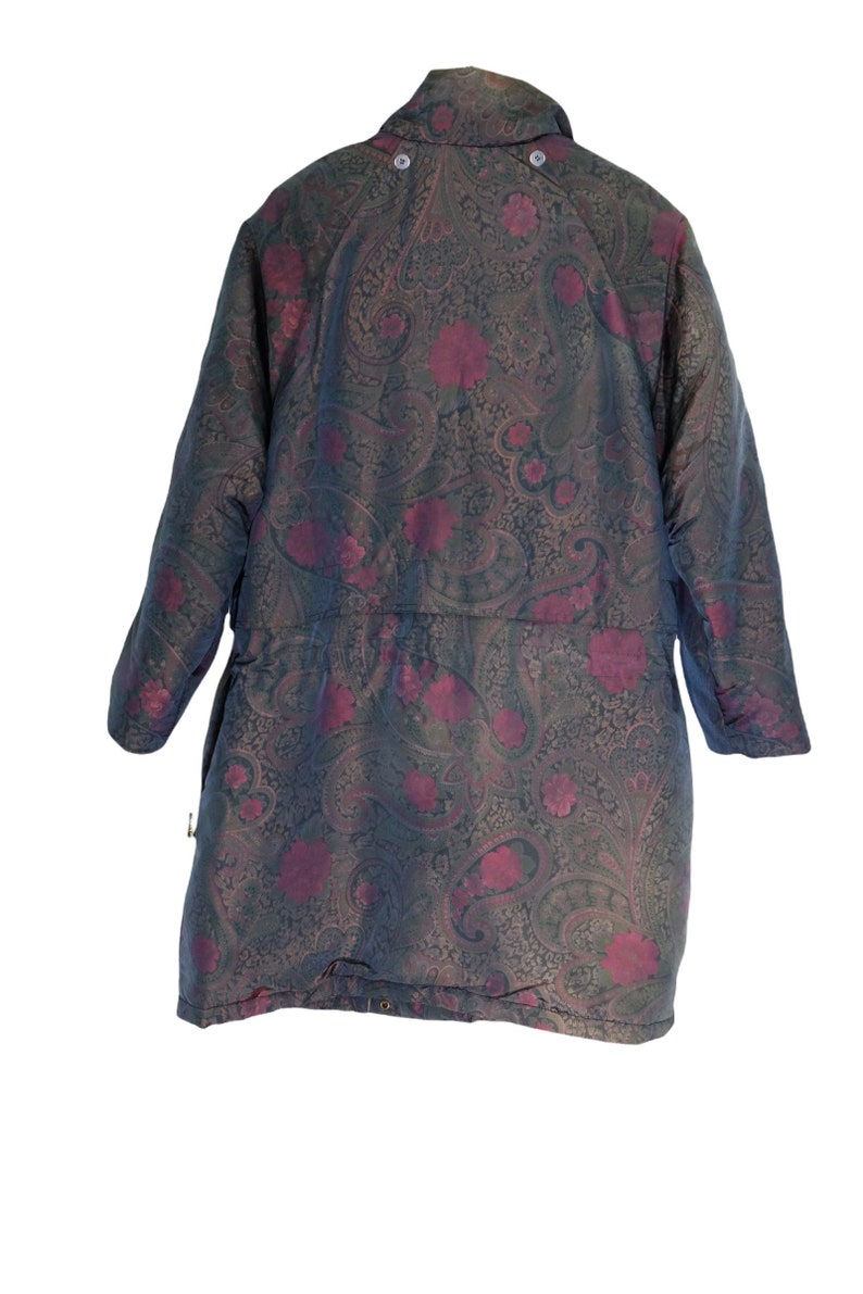 May include: A long-sleeved, paisley patterned jacket with a dark green and burgundy color scheme. The jacket has a high collar and a button closure.