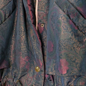May include: A dark blue and burgundy paisley patterned jacket with a zipper closure and a drawstring waist.