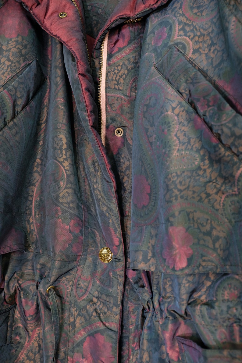 May include: A dark blue and burgundy paisley patterned jacket with a zipper closure and a drawstring waist.