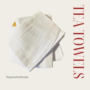 May include: Three white tea towels folded on top of each other. The towels are made of a soft, absorbent fabric. The text "TEA TOWELS" is written in red letters on the right side of the image.