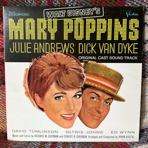 May include: A square vinyl record cover for the Walt Disney Mary Poppins original cast soundtrack. The cover features illustrations of Julie Andrews and Dick Van Dyke, with yellow dotted text reading Mary Poppins and white text below.