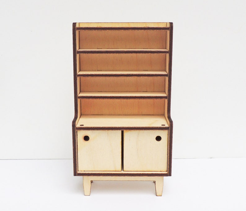May include: A wooden hutch with a cabinet and open shelves. The hutch is made of light wood with dark brown trim. The cabinet has two doors with a small round cutout on each door.