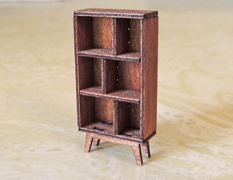 May include: A small wooden bookshelf with six shelves and four legs. The bookshelf is made of dark brown wood and has a rustic look.