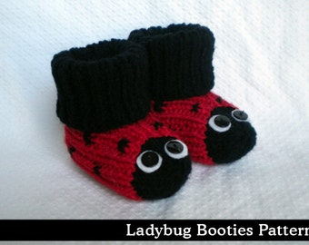 May include: Red and black knitted baby booties with black button eyes, resembling a ladybug.