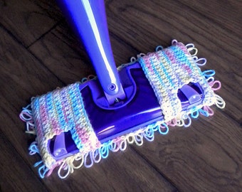 May include: A close-up of a purple Swiffer WetJet with a crocheted reusable pad in pastel pink, blue, and yellow. The text "reusable Swiffer pad pattern for dual spraying WetJets" is below the image.
