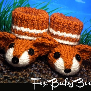 May include: A pair of knitted fox baby booties with orange and white stripes. The booties have black button eyes and a white nose.