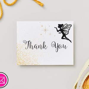 May include: A white card with the words "Thank You" in elegant script, accompanied by a black silhouette of a fairy blowing a kiss. Gold glitter and star accents add a touch of sparkle. The card is perfect for expressing gratitude.