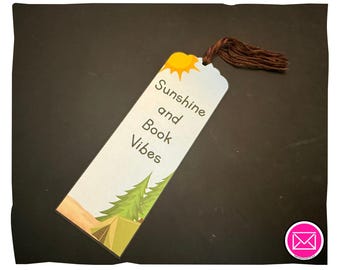 Puede incluir: Un marcapáginas rectangular con un gráfico de sol amarillo, pinos verdes y una tienda de campaña beige. El texto Sunshine and Book Vibes está impreso en marrón oscuro. Una borla de hilo marrón oscuro está unida a la parte superior.