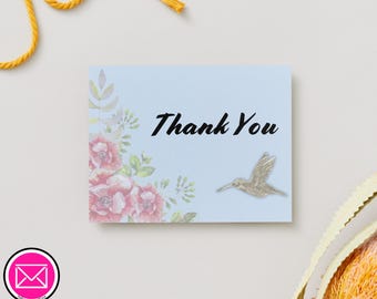 Puede incluir: Una tarjeta rectangular de color azul claro con el texto en negro Thank You, decorada con una ilustración en acuarela de flores rosas y hojas verdes en el lado izquierdo y un pequeño gráfico de colibrí plateado a la derecha.