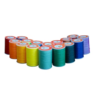 May include: A set of 16 spools of thread in various colors, including red, orange, yellow, green, blue, and purple. The spools are arranged in a semi-circle.