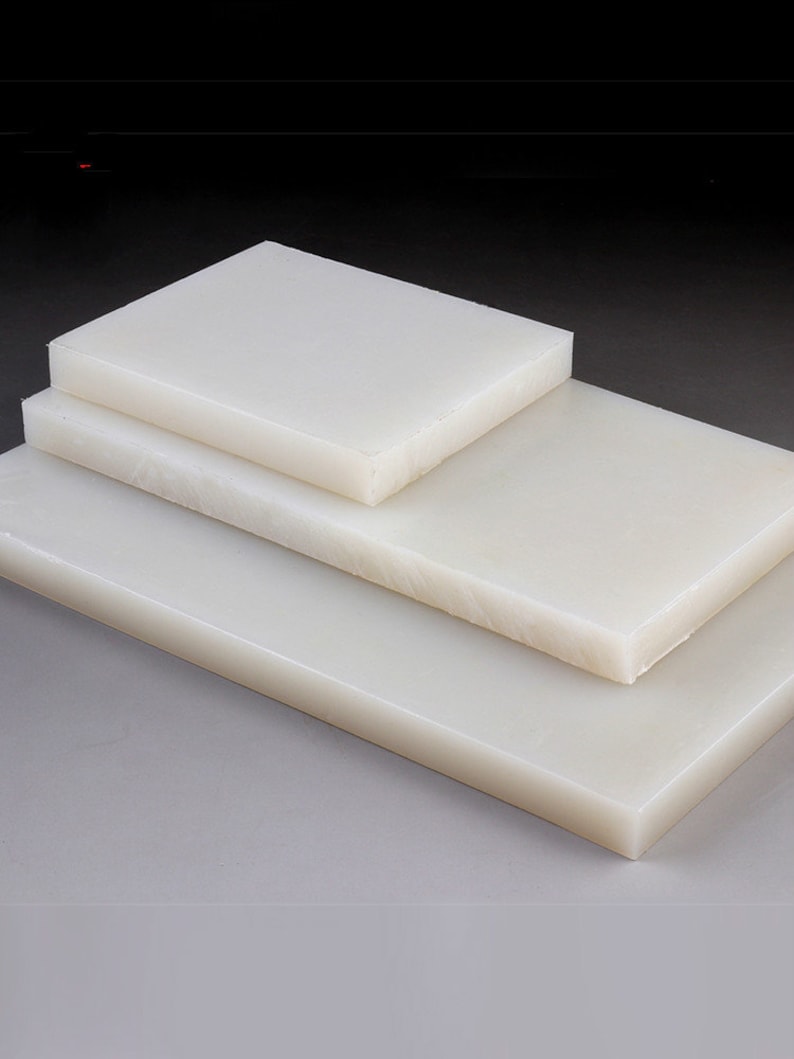 May include: Three white plastic sheets stacked on top of each other. The sheets are smooth and have a slight sheen.