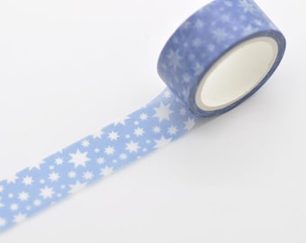 May include: A roll of blue washi tape with a repeating pattern of white stars. The tape is unrolled, revealing the star pattern. The tape is on a white background.