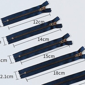 K&ouml;nnte beinhalten: F&uuml;nf marineblaue Rei&szlig;verschl&uuml;sse mit Messing-Zippern, die in der Gr&ouml;&szlig;e von 12 bis 18 Zoll reichen. Jeder Rei&szlig;verschluss wird in Zoll gemessen und mit der entsprechenden L&auml;nge beschriftet.