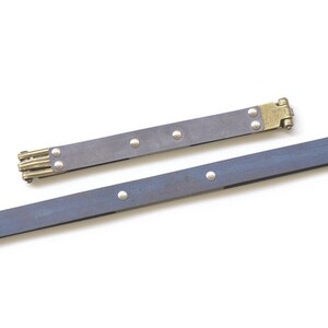 May include: Two antique-style, dark blue metal rulers with brass hinges and rivets. One ruler is larger than the other. The rulers are on a white background.