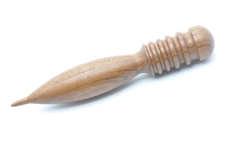May include: A wooden massage tool with a rounded, textured head and a long, tapered handle.