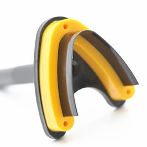 May include: A black and yellow plastic mouth guard with a handle. The mouth guard is designed to protect teeth during sports or other activities.