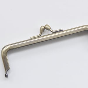 May include: An antique bronze-colored purse frame with a rectangular shape. The frame has rounded corners and a decorative clasp with two small, oval-shaped knobs. The frame is designed to be sewn into a purse or bag.