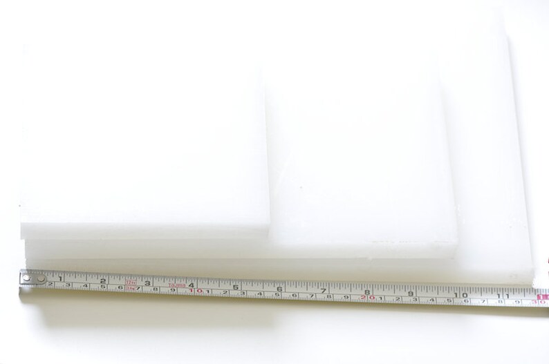 May include: Two white rectangular pieces of foam stacked on top of each other, measured with a ruler in inches.