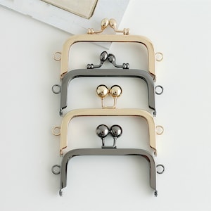 Puede incluir: Tres marcos de bolso en diferentes acabados: dorado, dorado rosa y negro. Cada marco tiene dos cierres metálicos redondos.