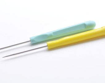 May include: Two metal knitting needles with plastic handles. One handle is light blue and the other is yellow.