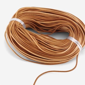 May include: A spool of brown leather cord, perfect for crafting projects. The cord is wound tightly and is ready to be used.