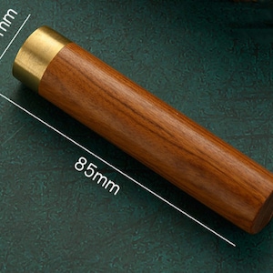 Puede incluir: Un tubo de madera y latón de 8,5 pulgadas de largo y 1,7 pulgadas de diámetro. El tubo está hecho de madera marrón oscuro con una tapa de latón en un extremo.