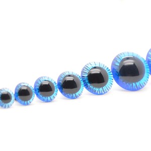 May include: Assortment of blue plastic safety eyes with black pupils, ranging in size from small to large.