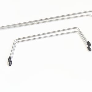 Puede incluir: Tres marcos metálicos plateados con puntas de goma negra. Los marcos están doblados en forma de U con una parte superior plana y lados angulados. Los marcos son de diferentes tamaños, el más grande en la parte superior y el más pequeño en la parte inferior.