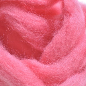 May include: A close-up of a pile of pink wool roving. The wool is soft and fluffy, and it is perfect for felting or spinning.