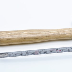 May include: A silver ball-peen hammer with a wooden handle. The hammer is 10.5 inches long and is measured with a ruler.