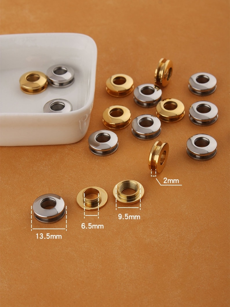 Pu&ograve; includere: Assortimento di occhielli in metallo dorato e argentato di diverse dimensioni. Gli occhielli hanno un diametro di 2 mm, 6,5 mm, 9,5 mm e 13,5 mm.