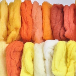 May include: A collection of wool roving in shades of yellow, orange, and red. The wool is arranged in rows, with each row containing a different color.
