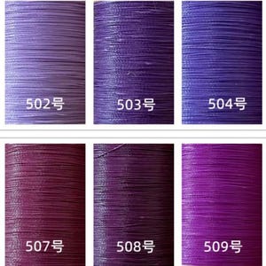 May include: A color chart of ten spools of thread in shades of purple, ranging from light lavender to deep violet. Each spool is labeled with a number from 501 to 510.